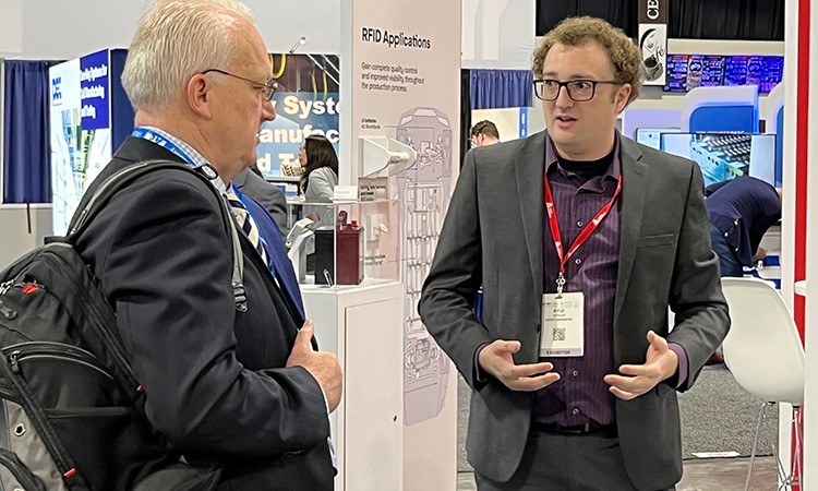 Photo showing a trade show attendee speaking with an Avery Dennison representative at the 2022 Battery Show in Novi, Michigan.
