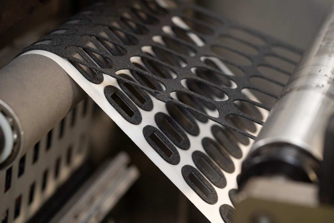 Photo closeup of a tape being die cut to an oval shape. Avery Dennison is the choice of many leading tape converters.