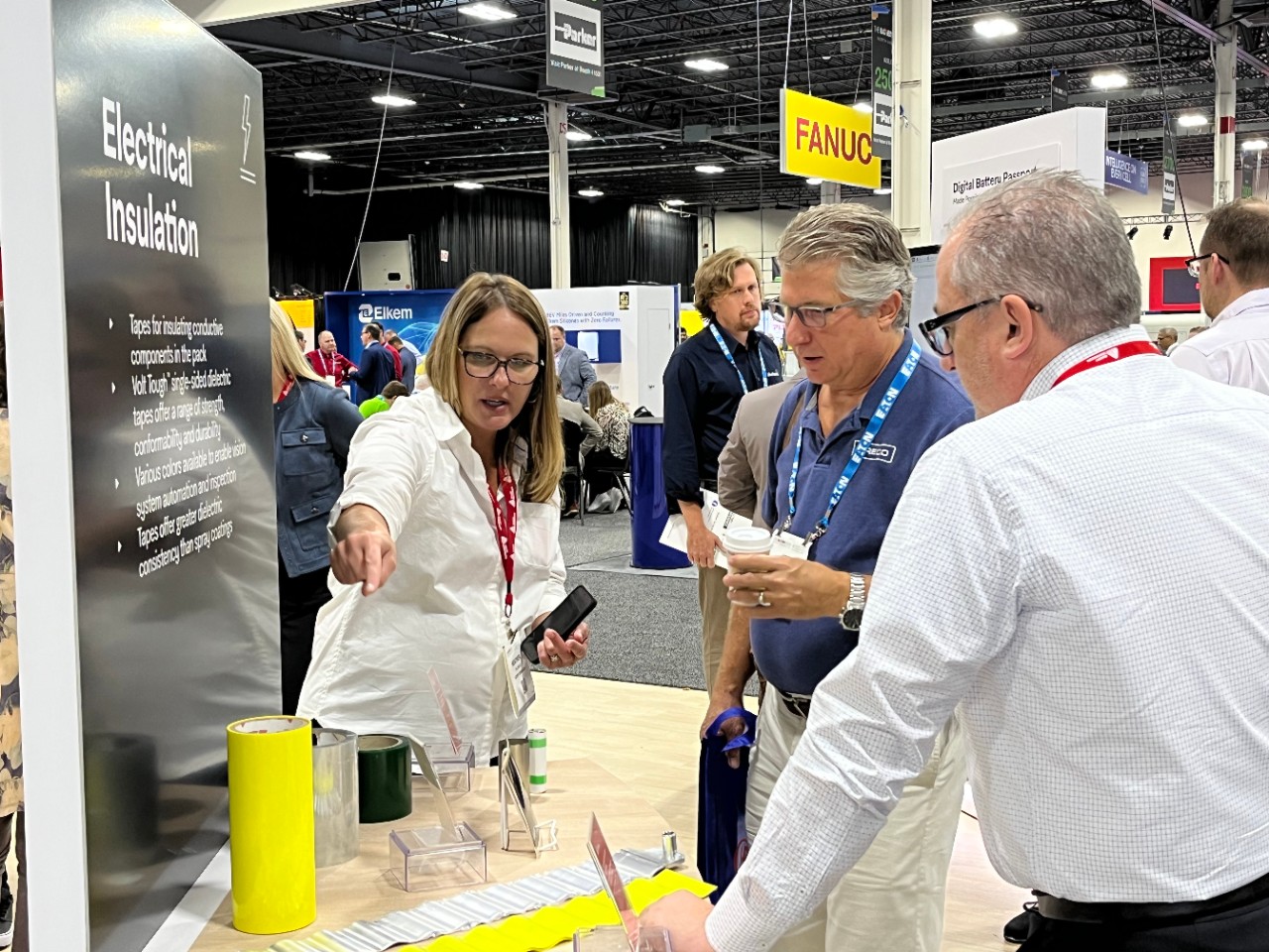Photo of Avery Dennison representatives speaking with a trade show attendee at the 2023 Battery Show North America.